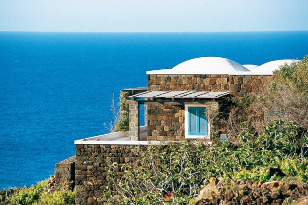 Vista panoramica dell'antico villaggio di Mursia con tombe a Sesi, cielo limpido e macchia mediterranea tipica di Pantelleria